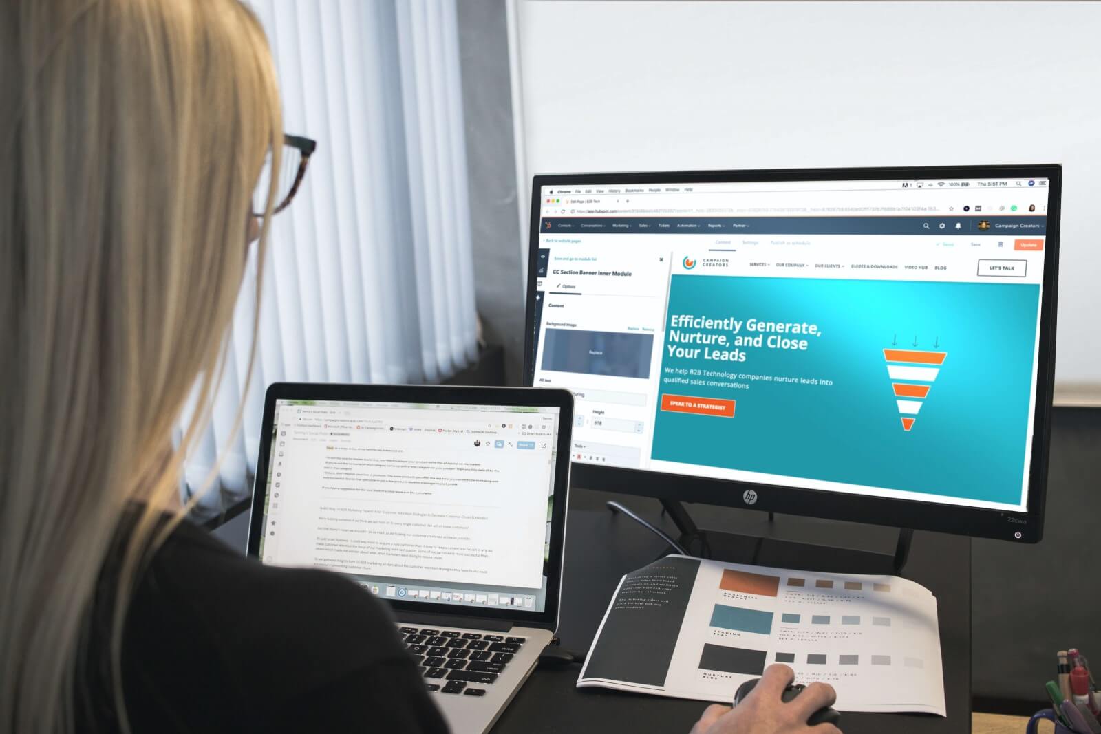 Woman using a laptop and desktop